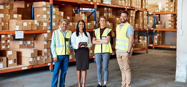 Four team members in a warehouse