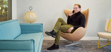 Man sitting in a chair calling on the phone