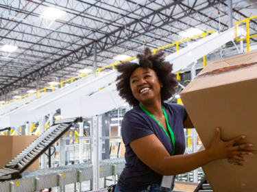 Glimlachende vrouw in warehouse met heldere LED-verlichting