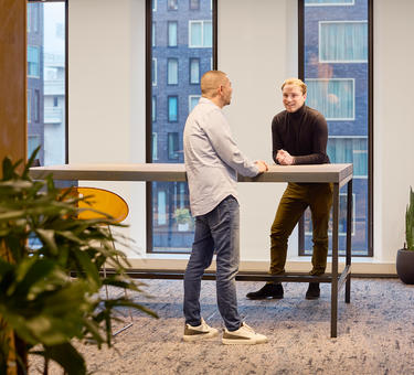 Two Prologis employees standing at a table in an open office space