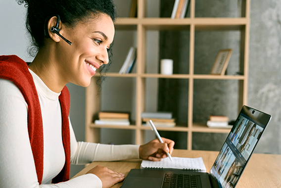 Vrouw die een online trainingssessie volgt op haar laptop Vrouw die een online trainingssessie volgt op haar laptop