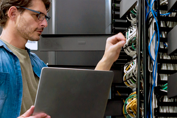 Smart Building bekabeling laptop IT-infrastructuurmedewerker met bril Smart Building bekabeling laptop IT-infrastructuurmedewerker met bril