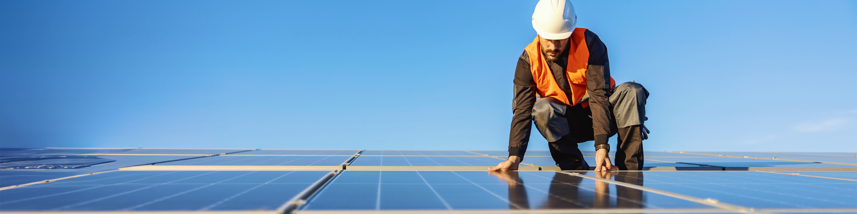Man met helm op zonnepanelen Man met helm op zonnepanelen