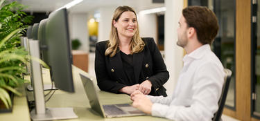 Two Prologis employees talking with each other at a desk
