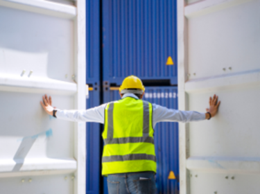 Medewerker die de deuren van de transportcontainer opent Medewerker die de deuren van de transportcontainer opent